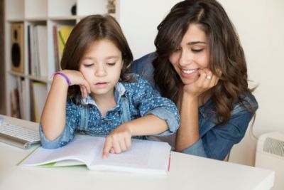 femme qui fait les devoirs à une jeune fillette